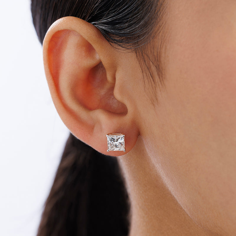 Close-up of a woman's ear wearing Keemti Jewels SQUARELUMIN Solitaire Stud Earrings with dark hair pulled back.