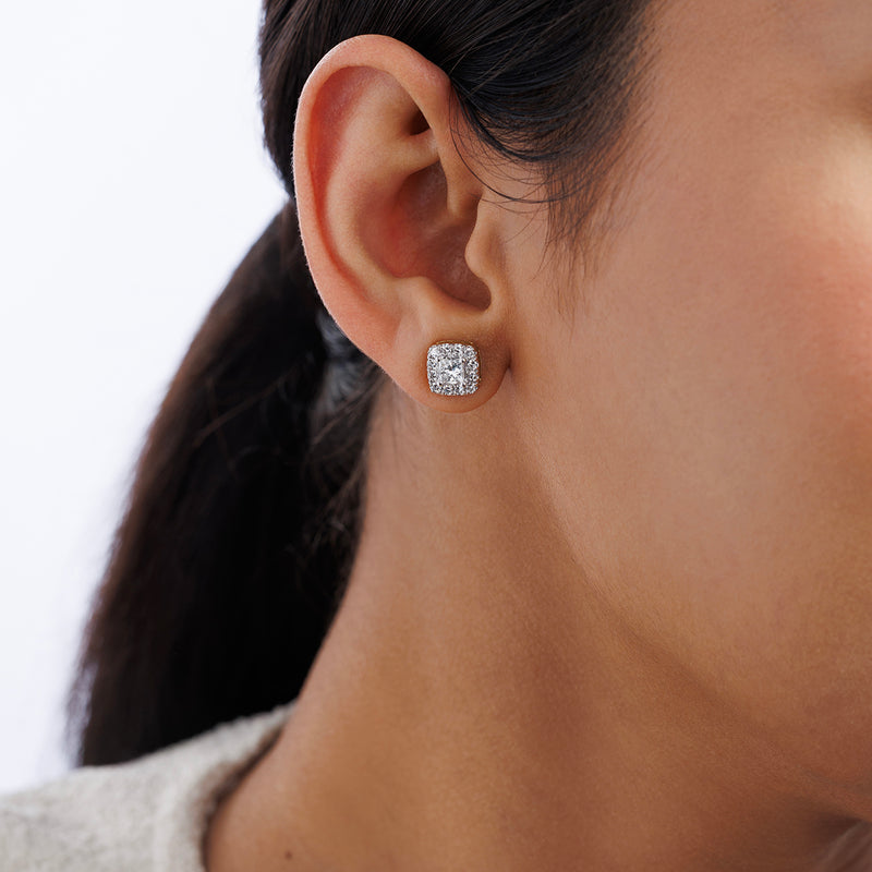 Close-up of a person wearing Keemti Jewels CLASSIC Princess Stud Earrings with sparkling round stones.