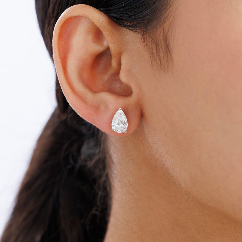 Close-up of a woman's ear wearing Keemti Jewels PEARLORIA Solitaire Stud Earrings in a pear-shaped prong setting.