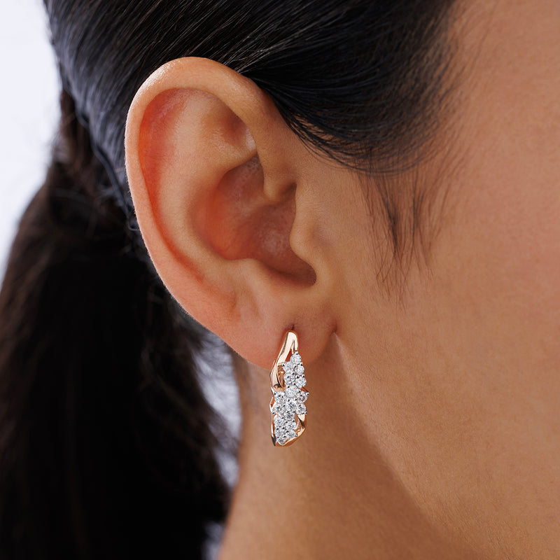 Close-up of a woman's ear wearing Keemti Jewels ILLUME Edge Hoop Earrings with three sparkling clear gemstones.