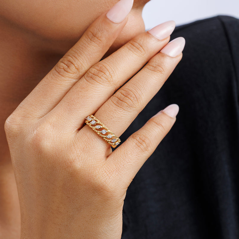 A hand with manicured nails wears Keemti Jewels' FLORAL Vine Band RING, held near the face, dressed in black.