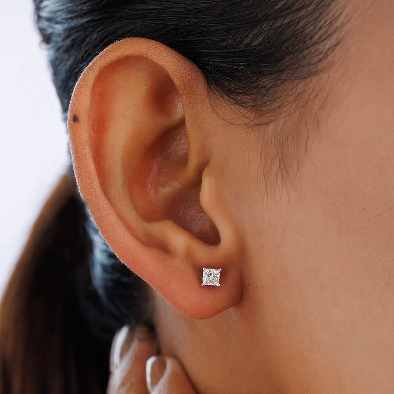 Close-up of a person’s ear wearing Keemti Jewels SQUARELUMIN Solitaire Stud Earrings, dark hair pulled back.