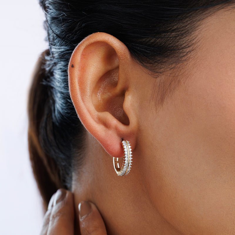 Close-up of a woman's ear in Keemti Jewels EVERLIGHT Curve Hoop Earrings, gold with a row of diamonds, hand on neck.