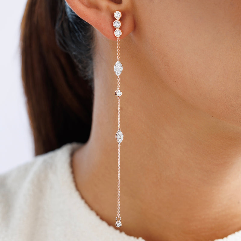 Close-up of a woman's ear wearing Keemti Jewels' TWINKLE Glow Sui Dhaga Earrings with bezel-set diamonds.