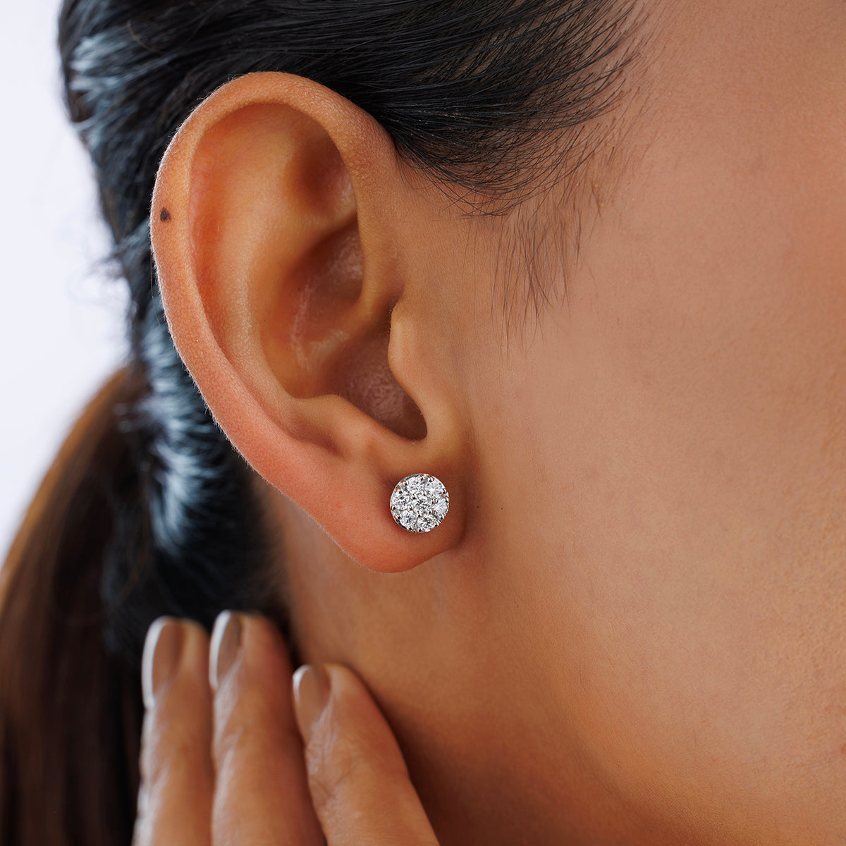 Close-up of a person wearing Keemti Jewels TINY <span>Spark Stud</span> EARRINGS; hand gently touching the neck.