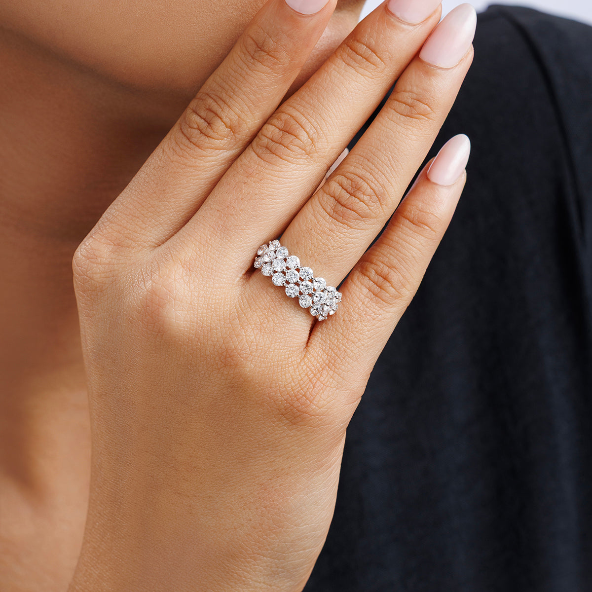 A manicured hand wears the Keemti Jewels RADIANT Bloom Mesh BAND, exuding elegance against a dark background.