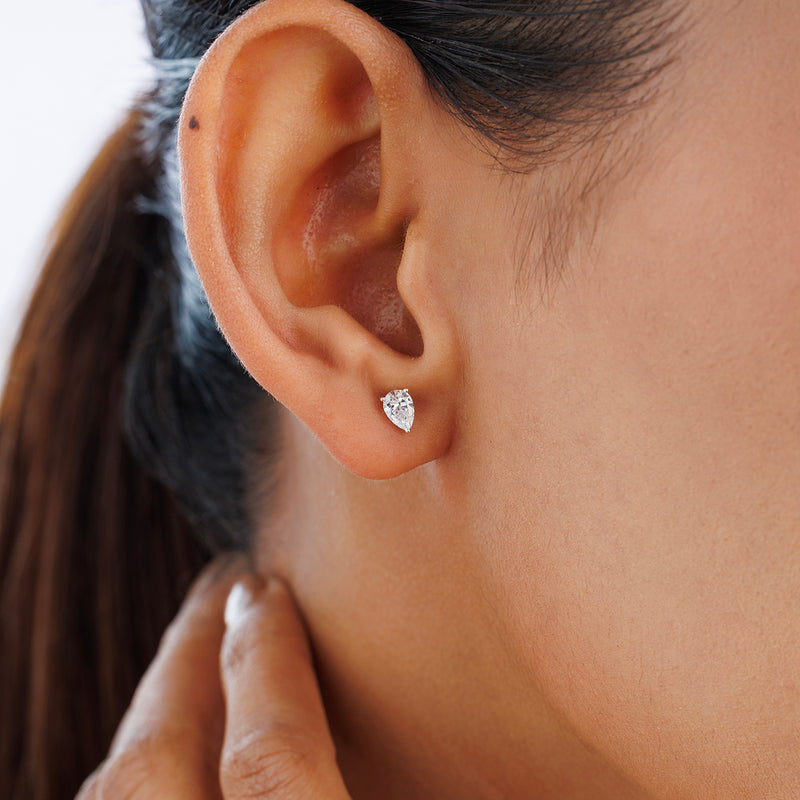 Close-up of a woman wearing PEARLUXE Solitaire Stud Earrings by Keemti Jewels; hand adds timeless shine.