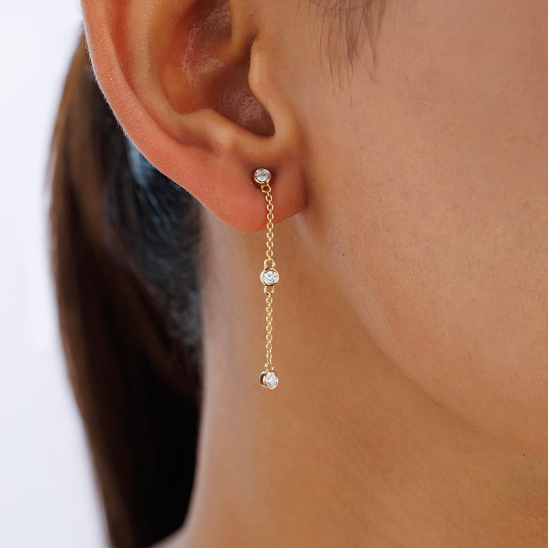 Close-up of a woman's ear wearing Keemti Jewels TRIO Trail Dangler Earrings in a delicate, dangling silhouette.