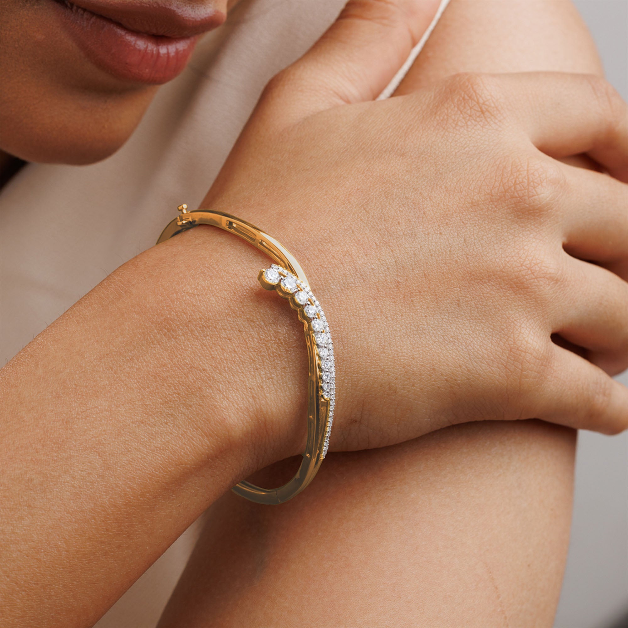Close-up of a person wearing the Keemti Jewels Crescent Spark Oval Bracelet, a luxury gold piece with sparkling gems.