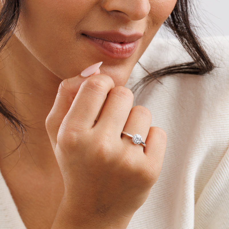 Halo solitaire ring on hand with round center stone in silver vermeil