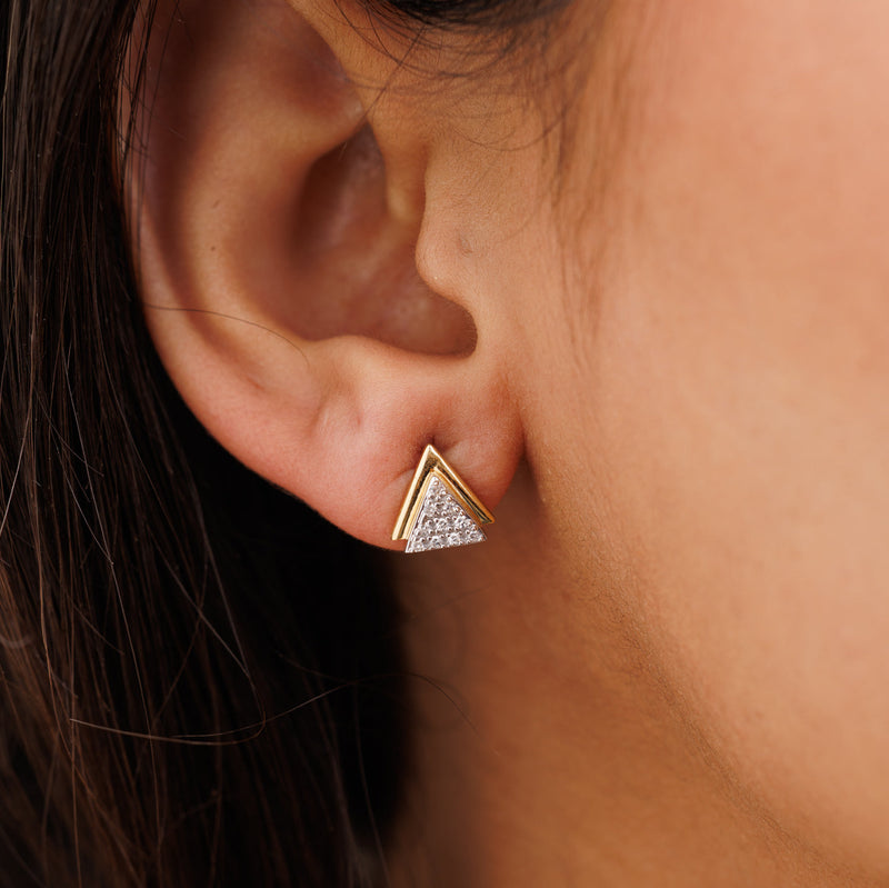 Triangle spark stud earrings on ear: gold border with silver glitter pavé triangle