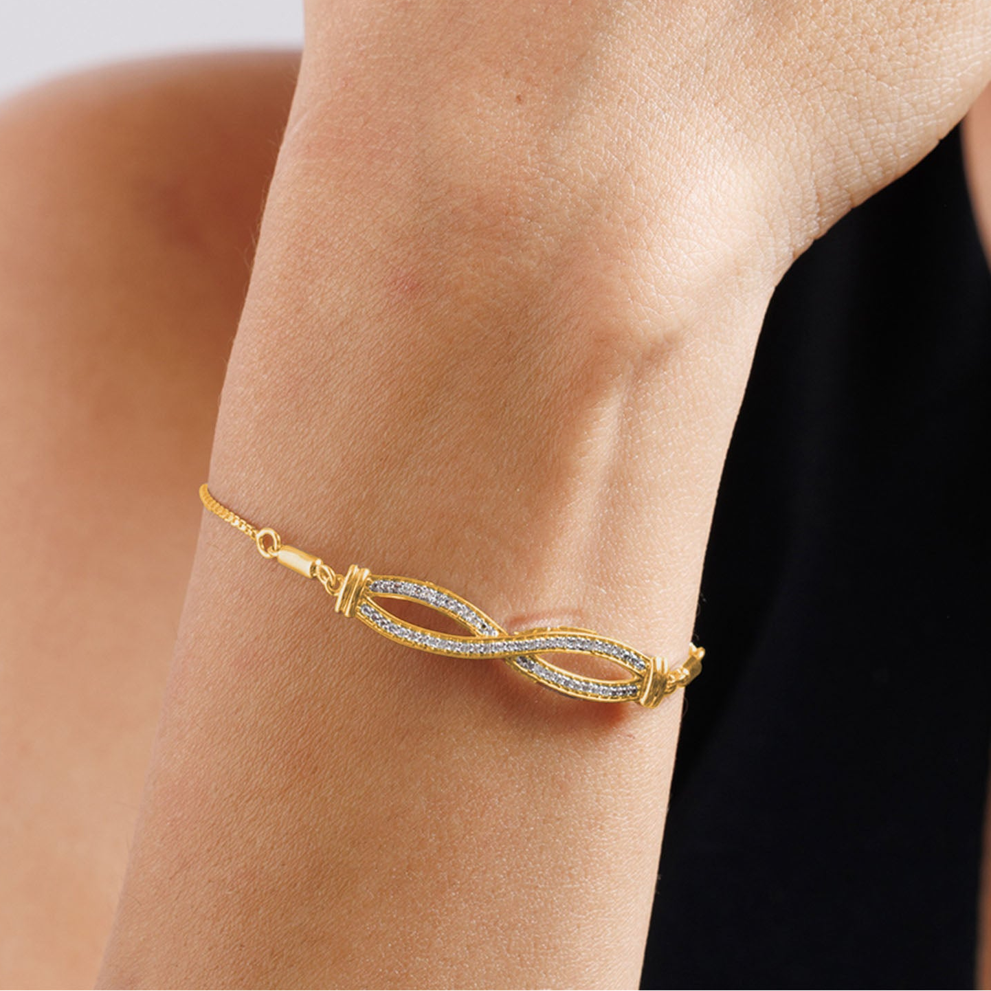 Keemti Jewels' Infinity Diamond Bolo Bracelet shines on the wrist, paired with a black top for modern elegance.
