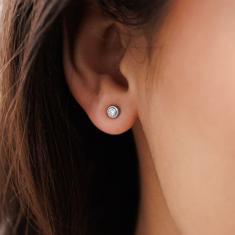Close-up of a person's ear wearing Keemti Jewels' Classic Everyday Shine Stud Earrings with clear, diamond-like stones.