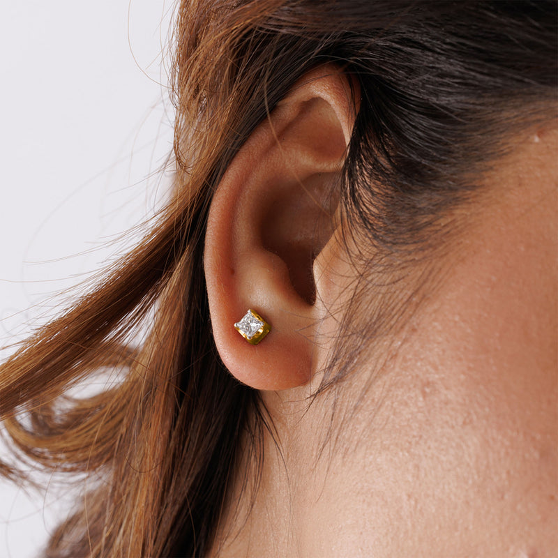 Close-up of an ear wearing Keemti Jewels' Modern Luxe Cube Stud Earring with a clear gemstone solitaire.