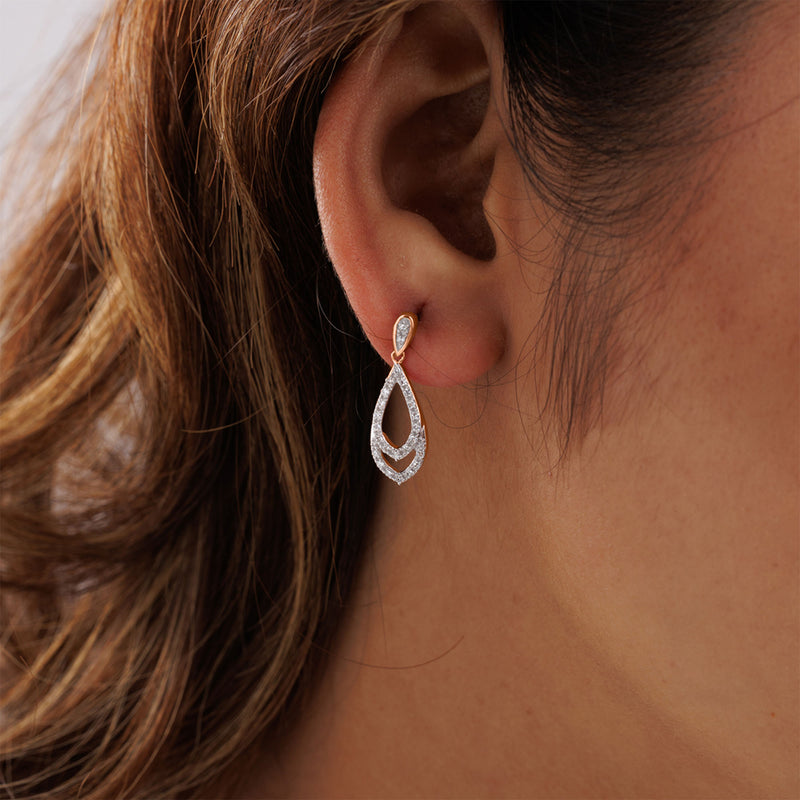 A woman's ear adorned with Keemti Jewels' Teardrop Dangling Earrings, diamond accents glimmer beneath her hair.