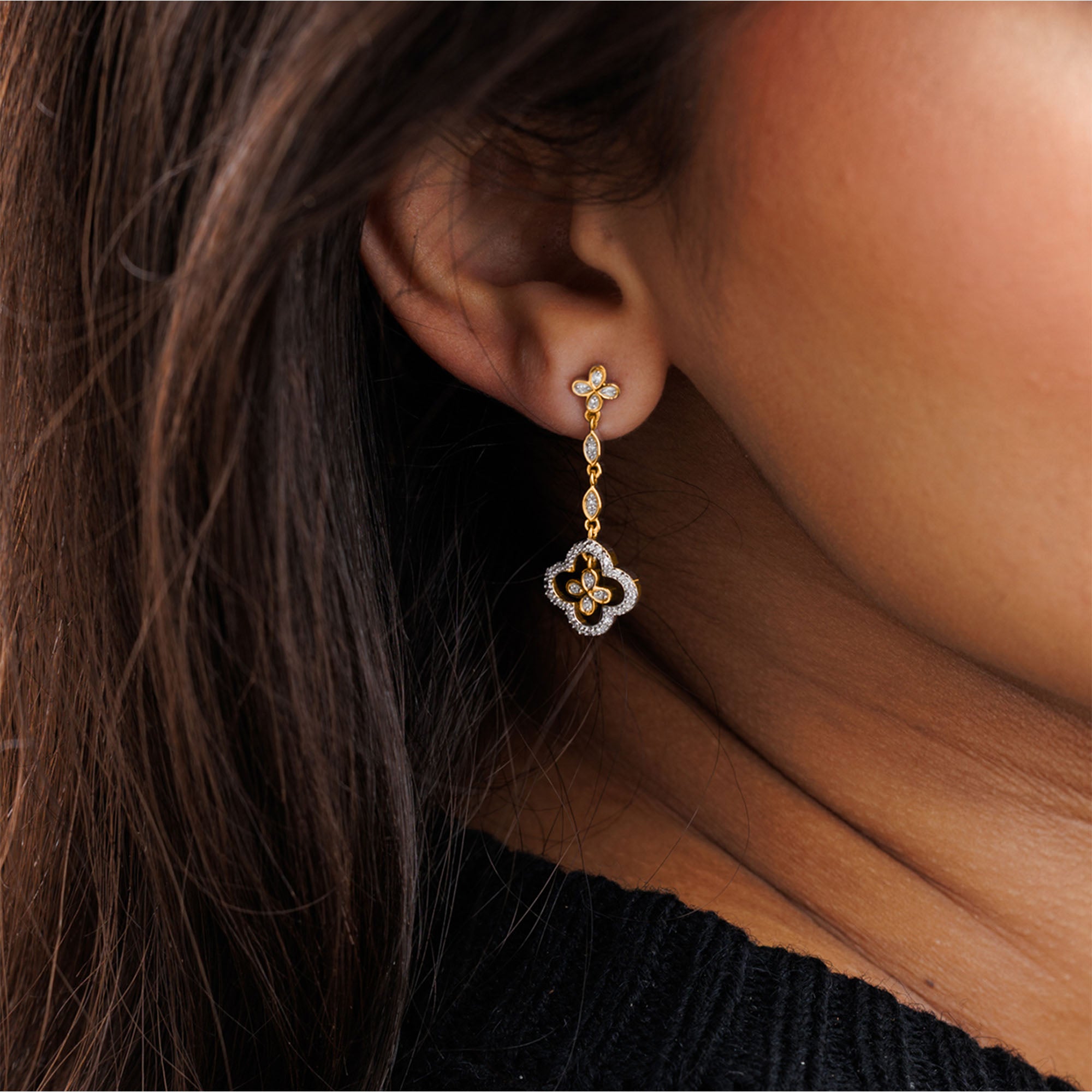 A close-up of a woman's ear in Keemti Jewels Ornate Grace Clover Earrings, gold with sparkling lab-grown diamonds.