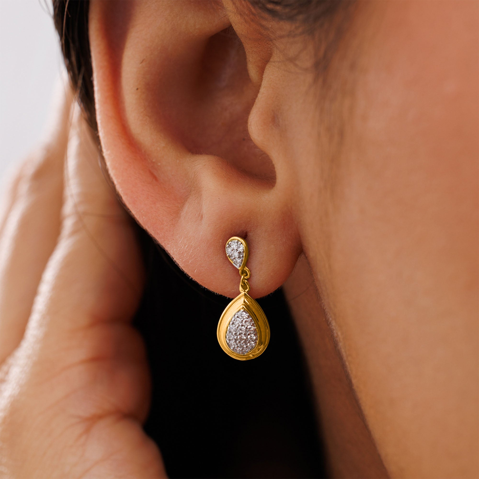 Close-up of a hand near the face, highlighting Keemti Jewels’ Classic Teardrop Statement Earrings for an elegant touch.