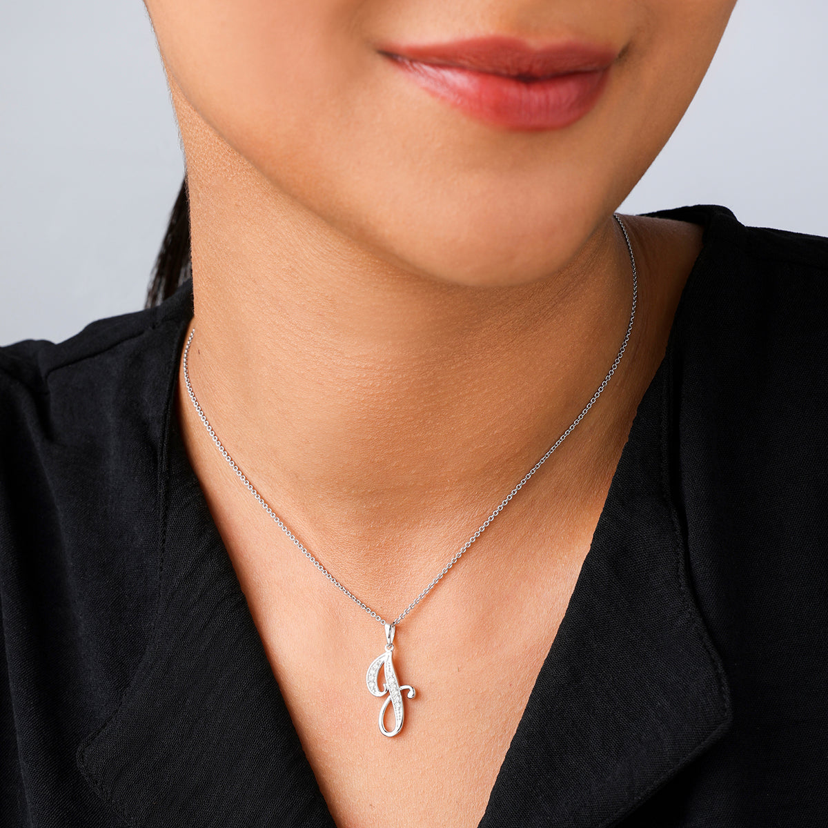 A woman in a black top wears the Keemti Jewels CLASSIC J Signature PENDANT for an elegant look.
