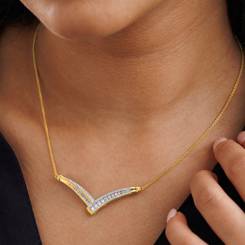 Keemti Jewels Multi-Stone Chevron Necklet with V-shaped pendant, hand on chain, worn over dark clothing.