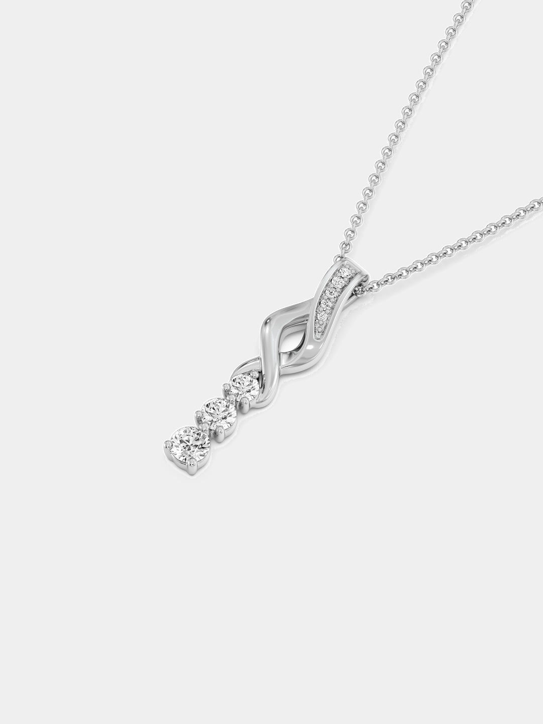 Three-stone twirl drop necklace on neckline: silver chain with sparkling swirl pendant