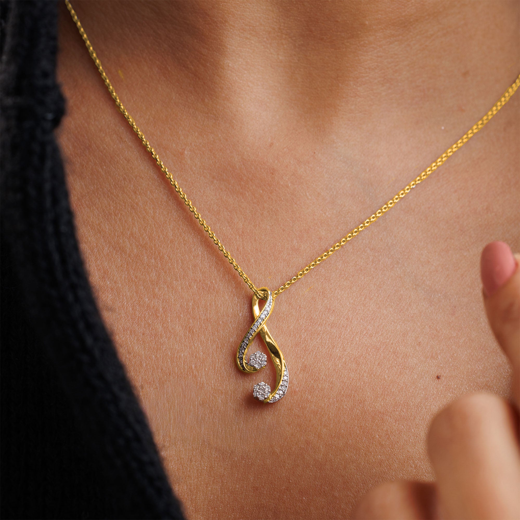 Keemti Jewels' Infinity Twist Chain Necklet with a curved pendant shines elegantly on black clothing at the neck.