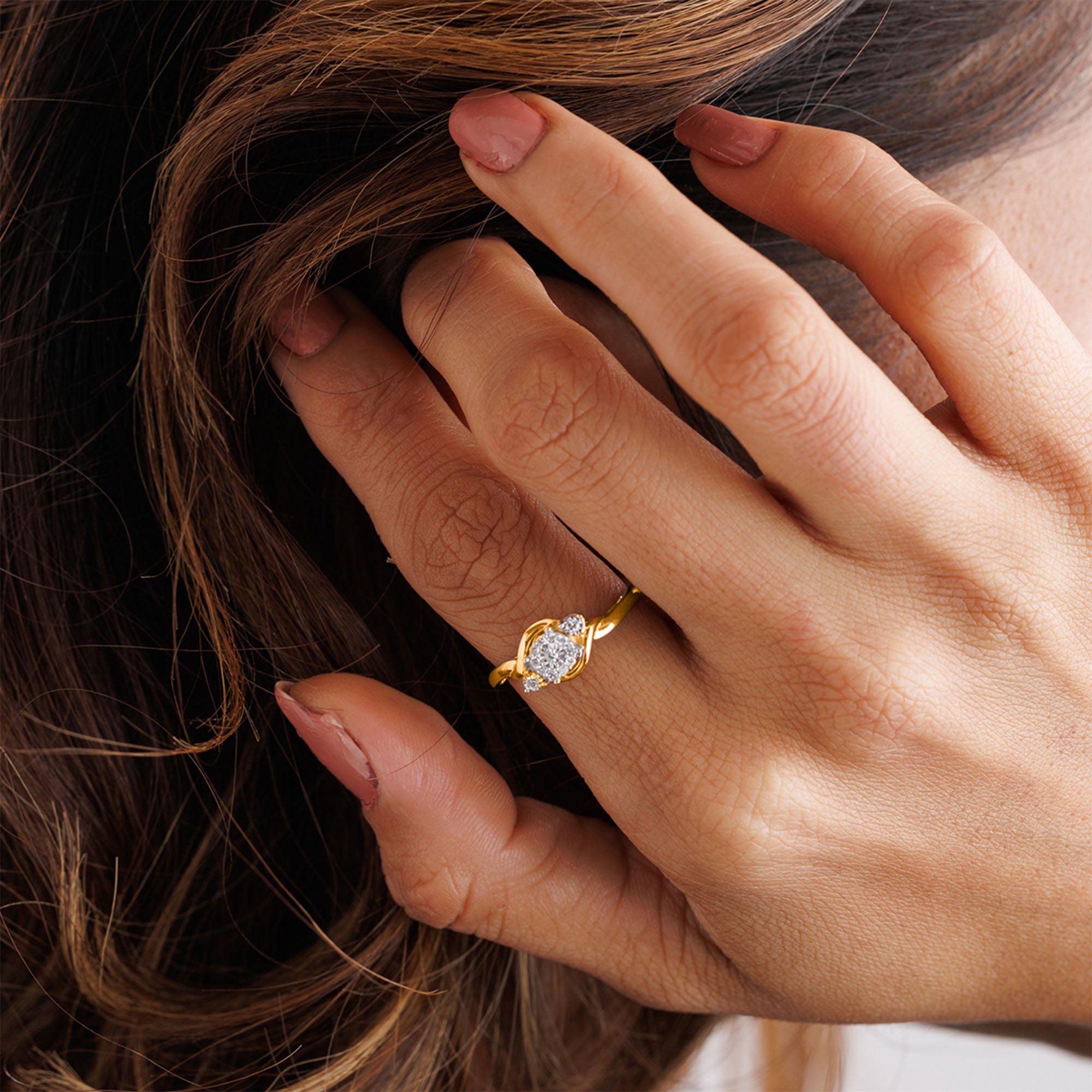 A manicured hand in Keemti Jewels' Two-Tone Accent Ring with an oval stone gently touches flowing hair.