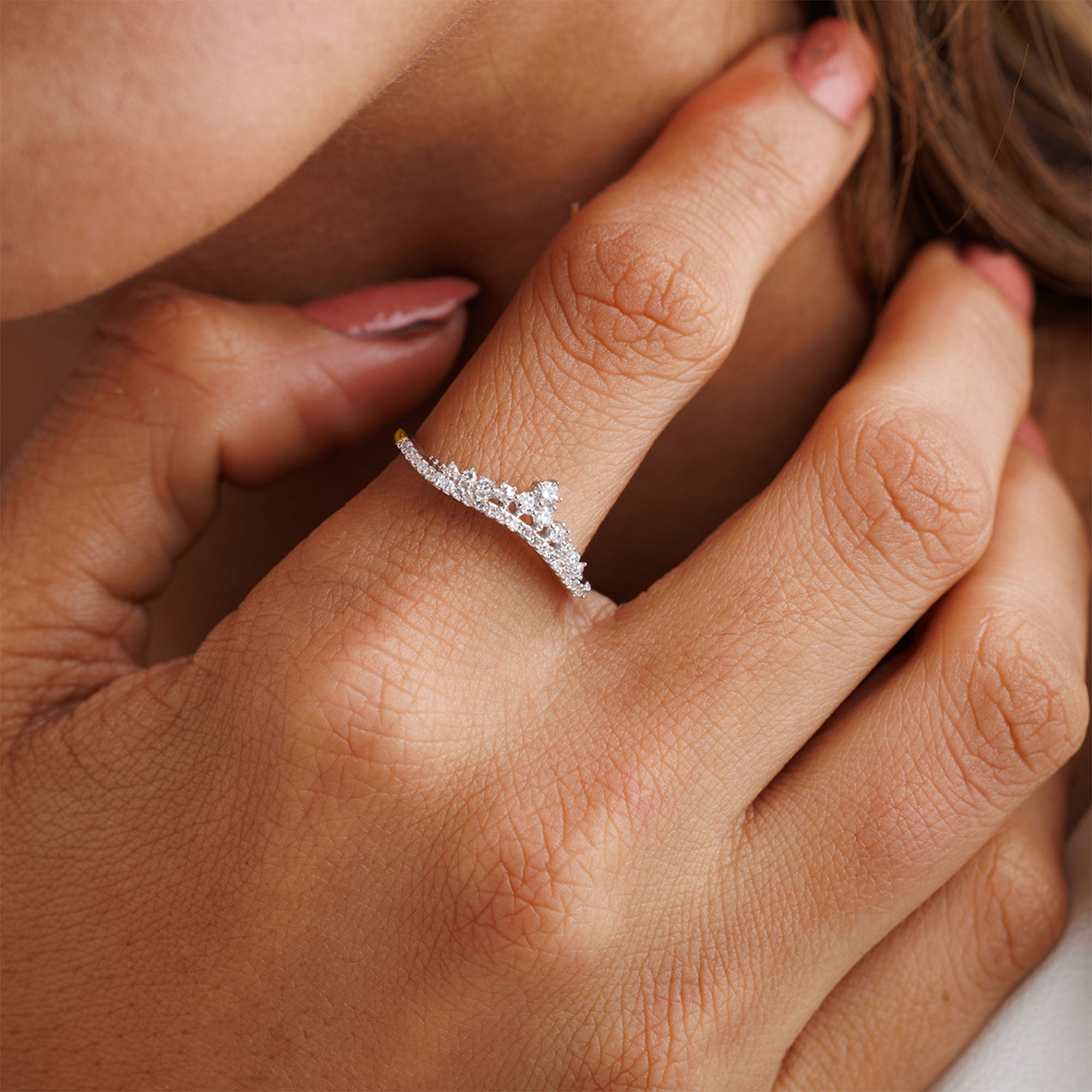 A hand with manicured nails showcases Keemti Jewels’ Inversed Crown Diamond Ring, highlighting smooth, radiant skin.