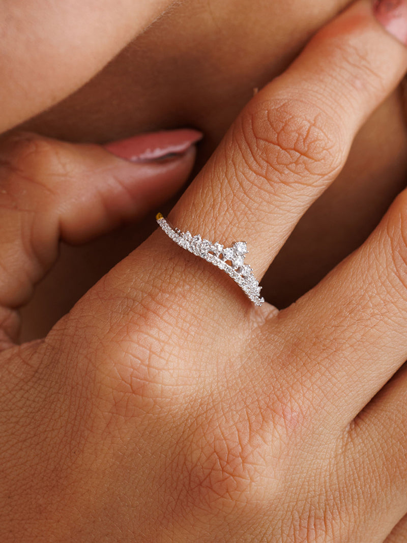 A hand with manicured nails showcases Keemti Jewels’ Inversed Crown Diamond Ring, highlighting smooth, radiant skin.