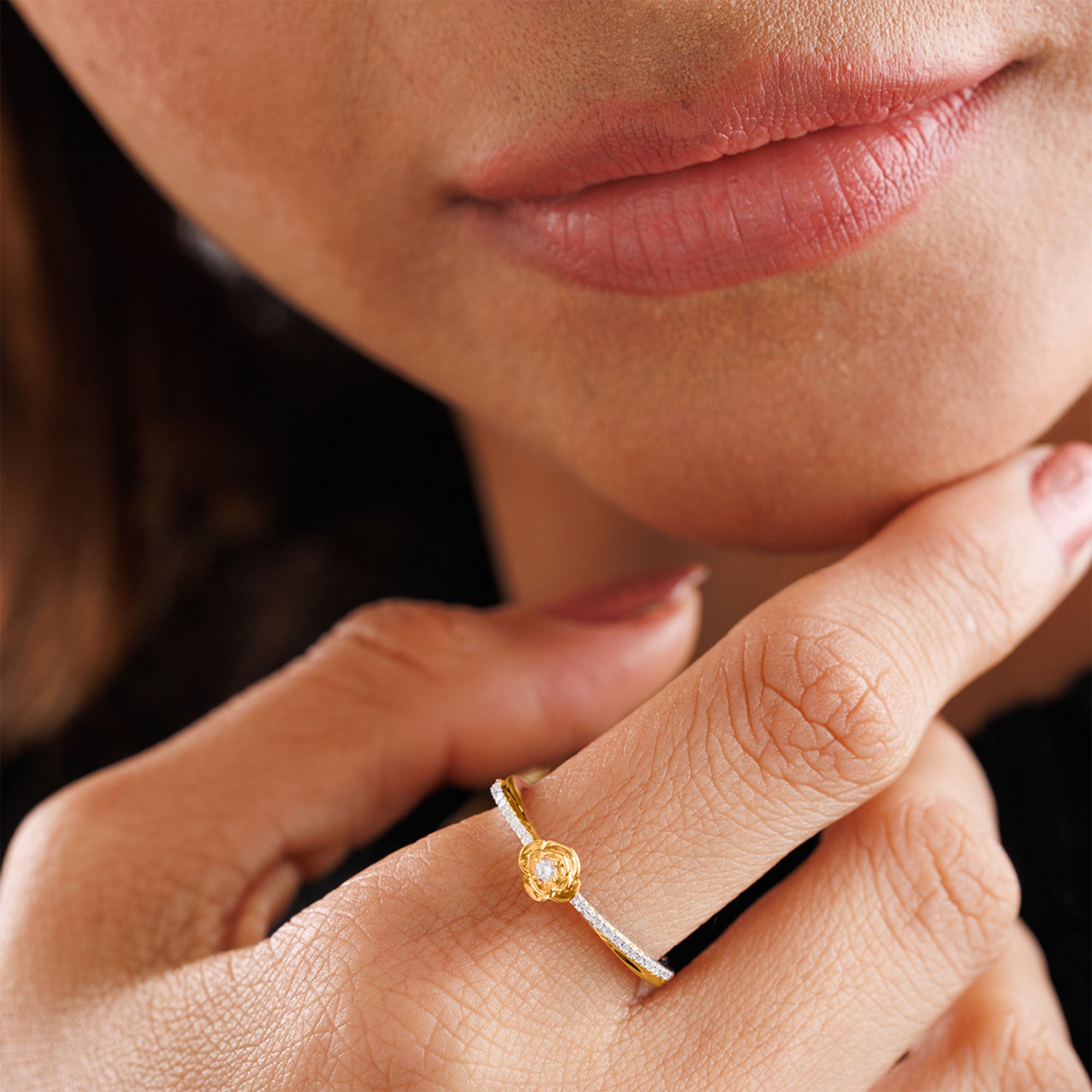 A person touches their lips, wearing Keemti Jewels' Petal Blush Promise Ring featuring a yellow gemstone.