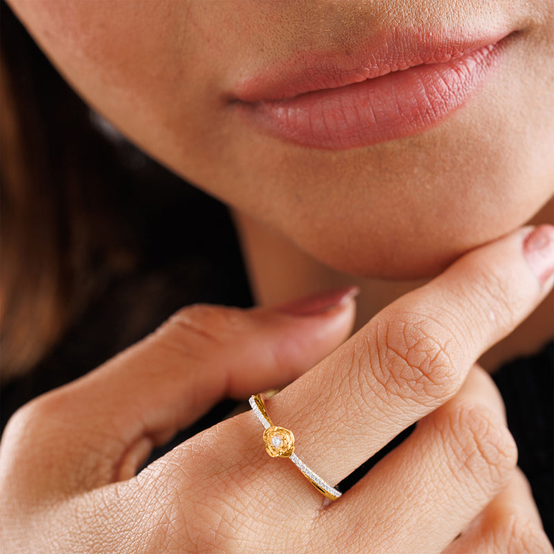 A person touches their lips, wearing Keemti Jewels' Petal Blush Promise Ring featuring a yellow gemstone.