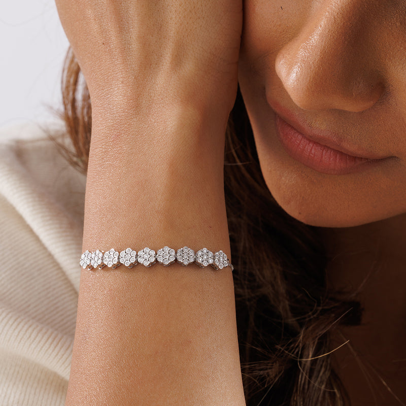 A woman rests her face on her hand, highlighting Keemti Jewels' Petal Cluster Bolo Bracelet on her wrist.