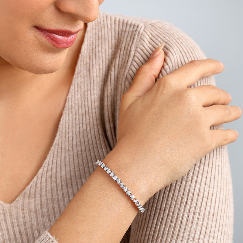 Woman wearing a ribbed beige top and Keemti Jewels Adjustable Diamond Tennis Bracelet, smiling gently.
