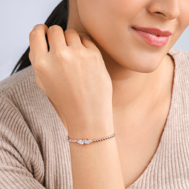 A woman wears a beige sweater and a Keemti Jewels Adjustable Twin Marquise Diamond Bracelet, hand near her chin.