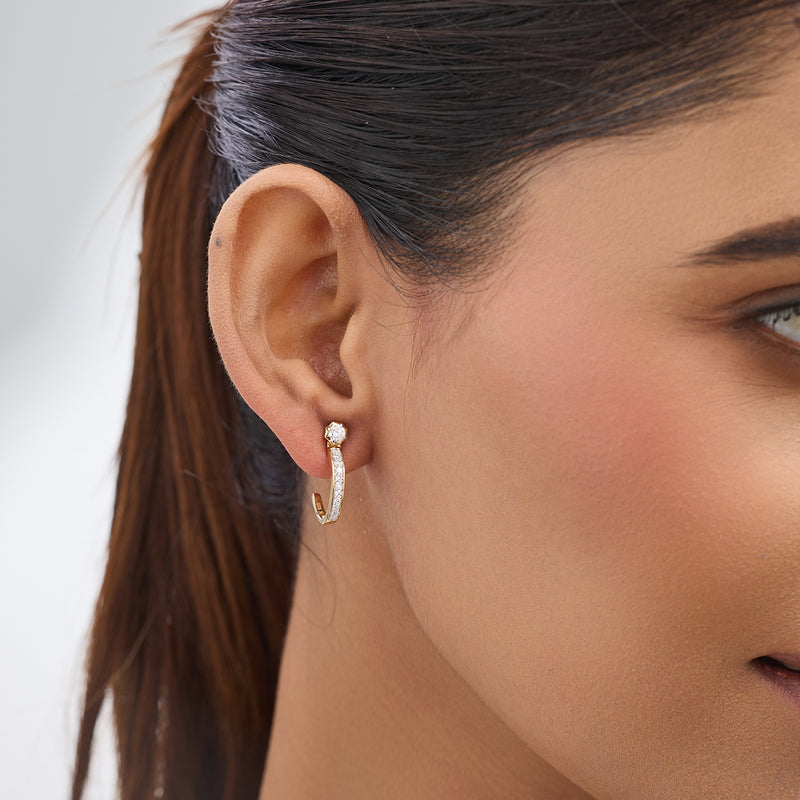 Close-up of a woman's ear wearing Keemti Jewels' Aura Blossom Diamond Ear Jackets—small gold hoops with a sparkling stud.