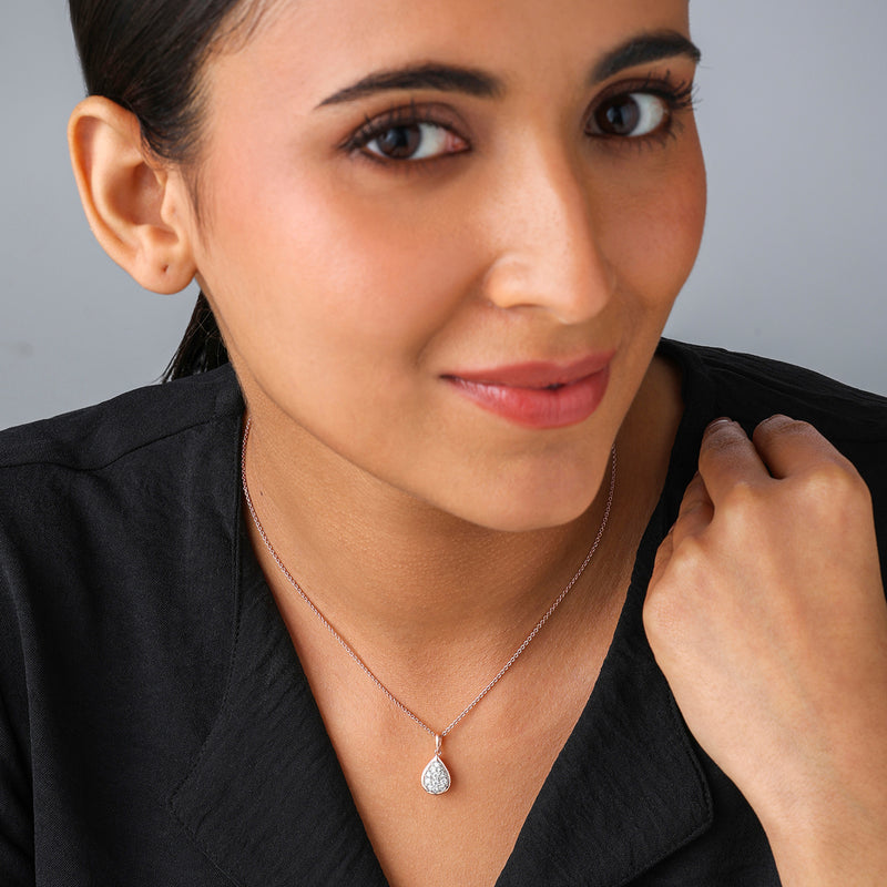 Woman wearing a black top and Keemti Jewels' Ropeglow Pear Diamond Pendant, smiling slightly at the camera.