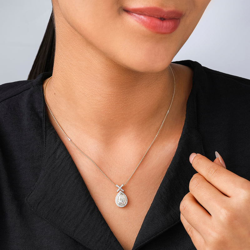 A woman in a black top touches the chain of a Keemti Jewels Pear Grace Diamond Pendant near her neck.
