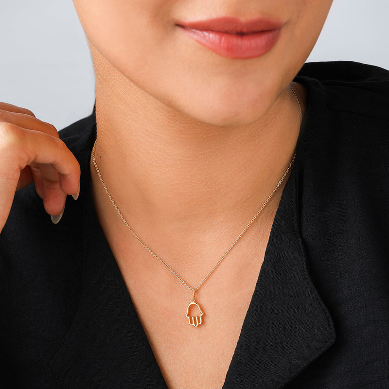 Woman wears Keemti Jewels' Blessed Hand Nazar Diamond Pendant with a black top, radiating serenity against a light background.