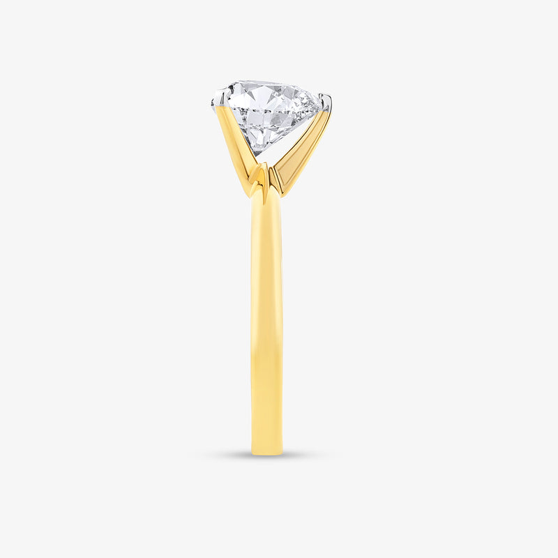 The Essential Heart Solitaire Ring by Keemti Jewels: a gold ring with a large diamond in a four-prong setting, side view.