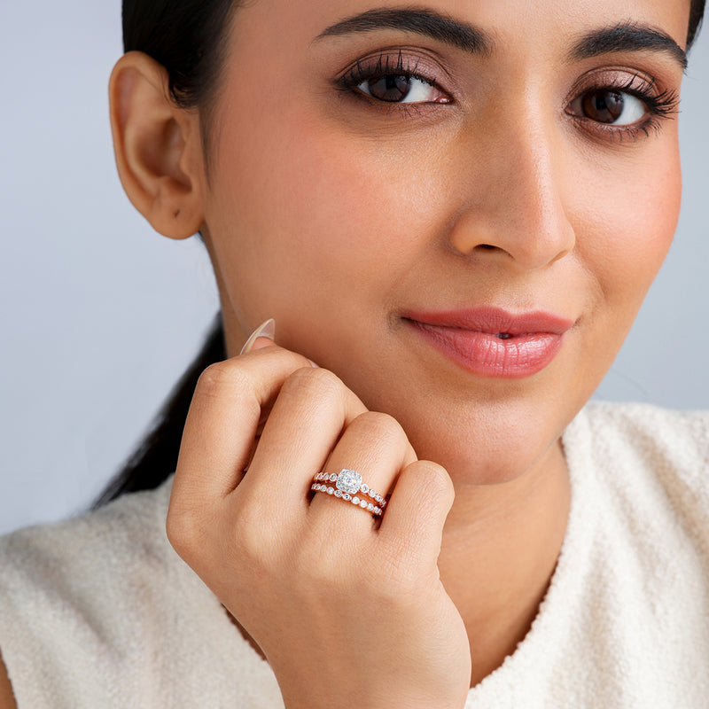 Woman smiles, wearing Keemti Jewels' Circle Of Forever Solitaire Ring and a stunning band with her sleeveless white top.