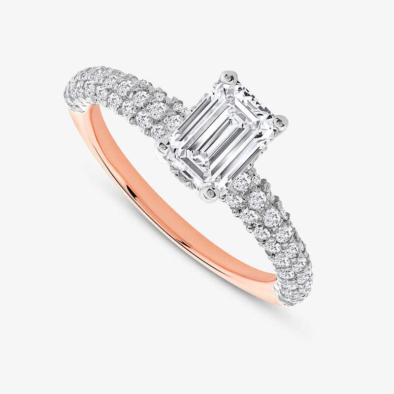 The Timeless Emerald Solitaire Ring by Keemti Jewels features rose gold with a large emerald-cut diamond and a diamond band.
