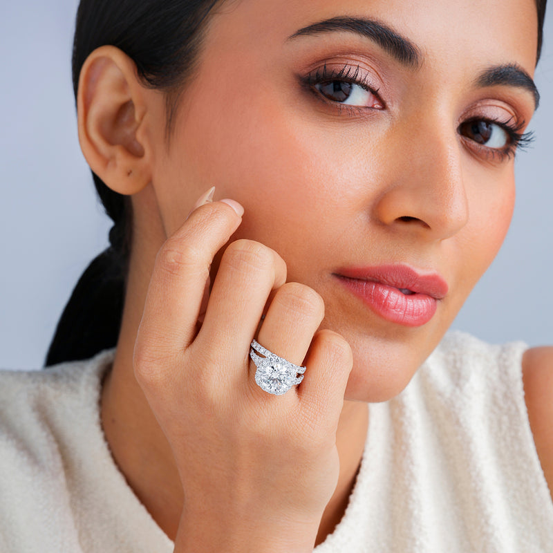 Woman with smooth skin touches her face, wearing the Pure Promise Round Halo Diamond Ring by Keemti Jewels.