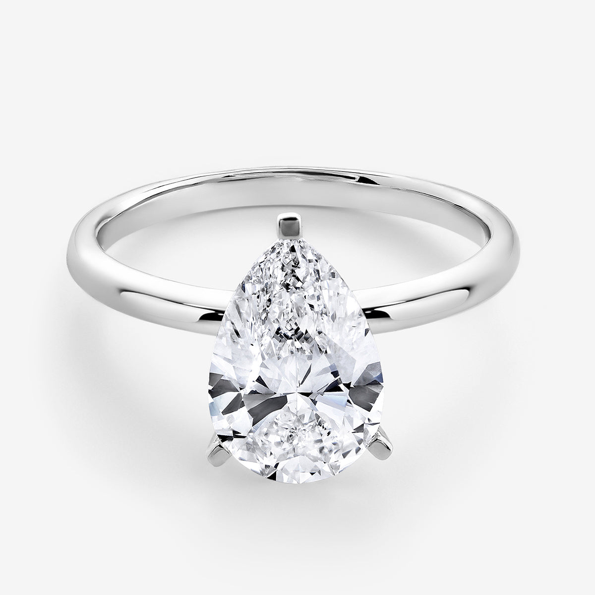 The EVERDEW Pear Solitaire Ring by Keemti Jewels features a silver band and a large pear-cut diamond.