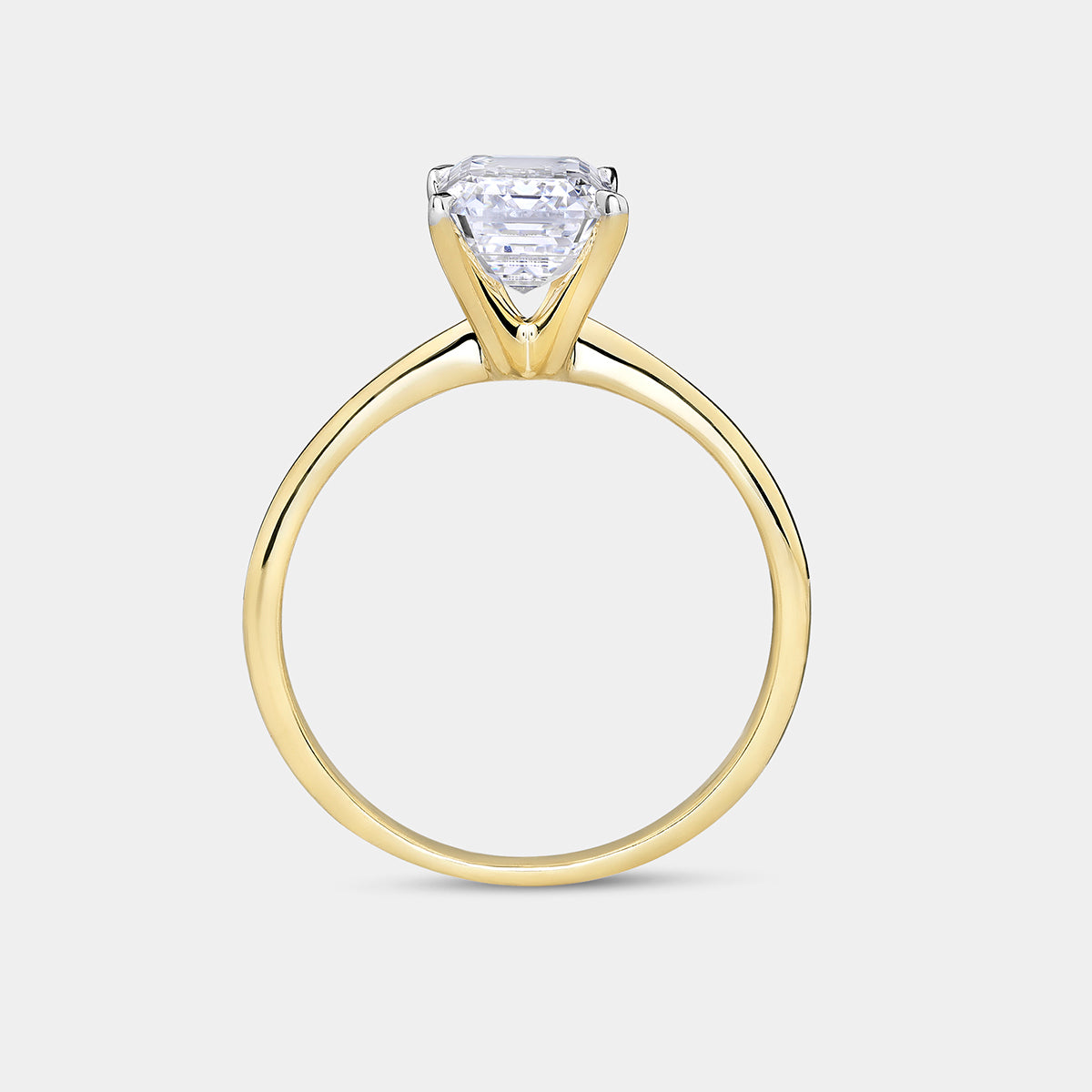 Keemti Jewels’ GRACE Emerald Solitaire Ring features a prong-set, triangular-shaped diamond in an elegant gold setting.