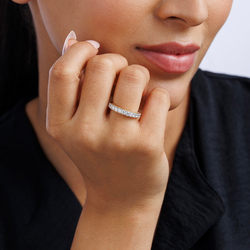 Thin oval pavé ring on finger, clear stones set along the band