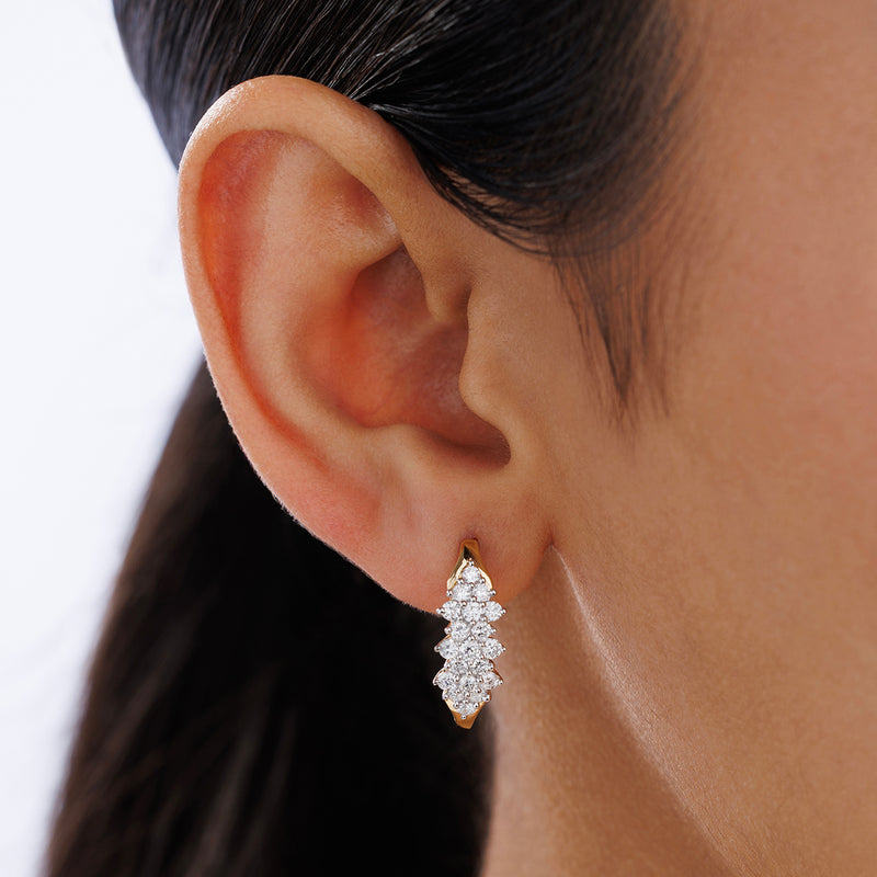 Close-up of a person’s ear wearing Keemti Jewels FLORAL Bliss Hoop EARRINGS in a gold, diamond floral design.