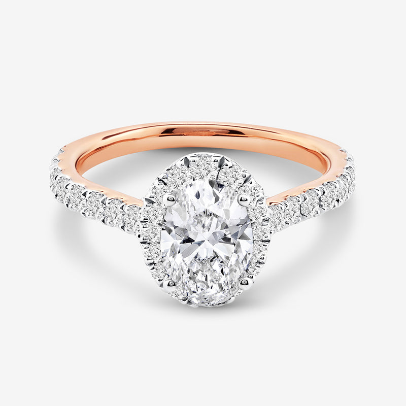 The CLASSIC Oval Mount Solitaire RING by Keemti Jewels features a rose gold band and pavé diamonds, shown on white.