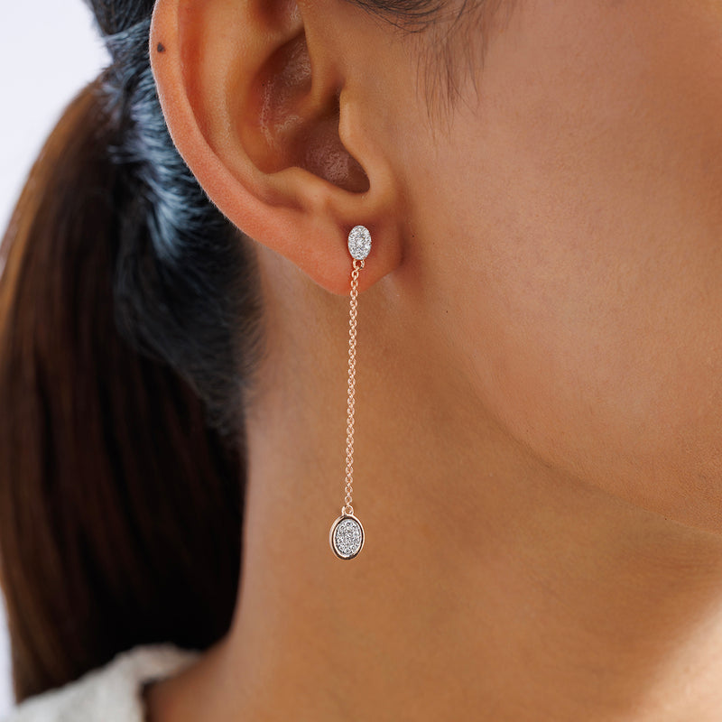 Close-up of a woman wearing Keemti Jewels' AMARA Round Dangler Earrings with oval charms and round studs.