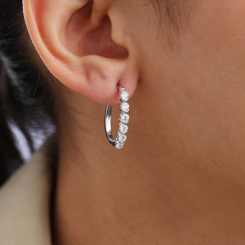 Worn on ear: vertical halo hoop earrings with five round stones, silver-tone finish