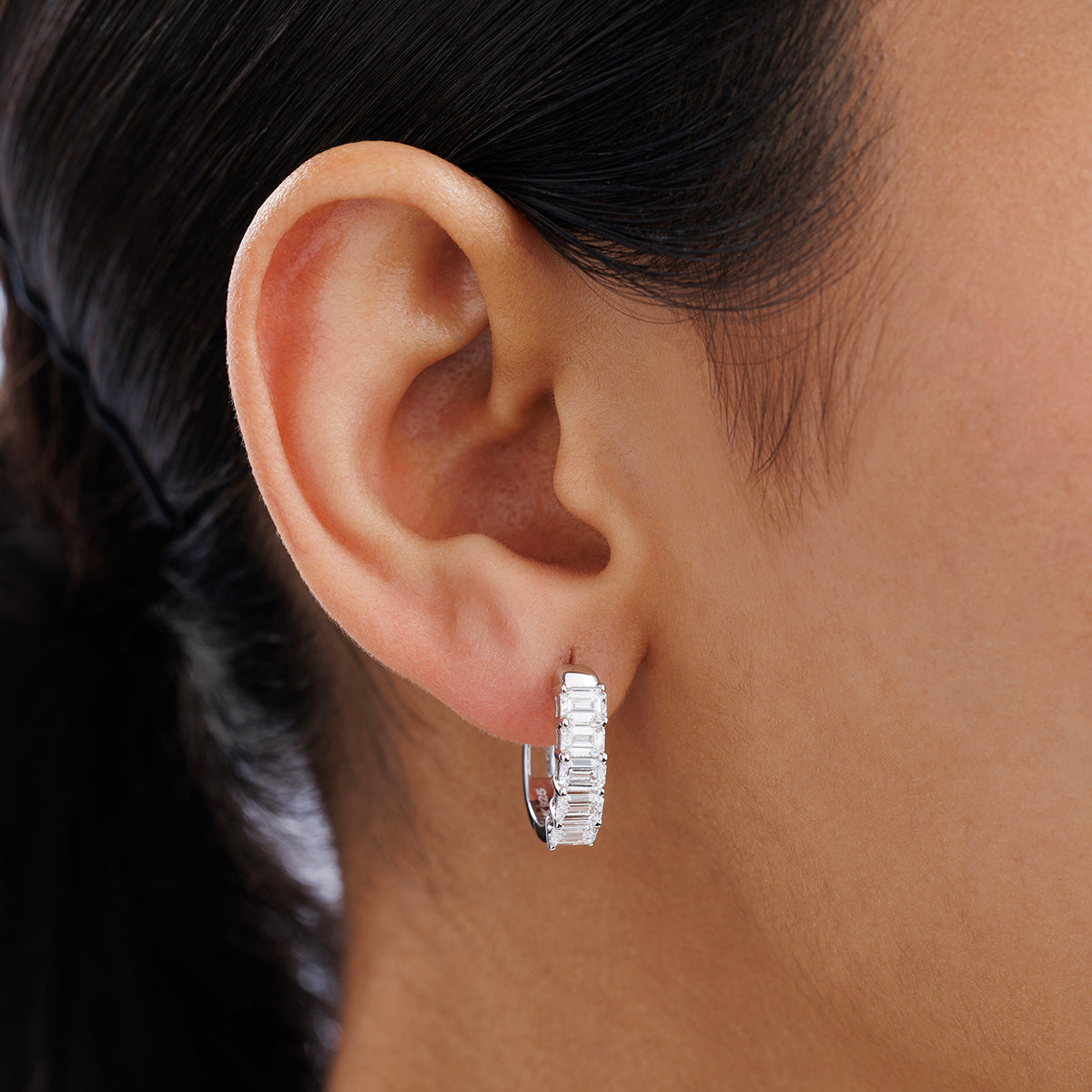 Close-up of a woman’s ear wearing Keemti Jewels ELYSIAN Hoop Earrings with channel-set clear gemstones.