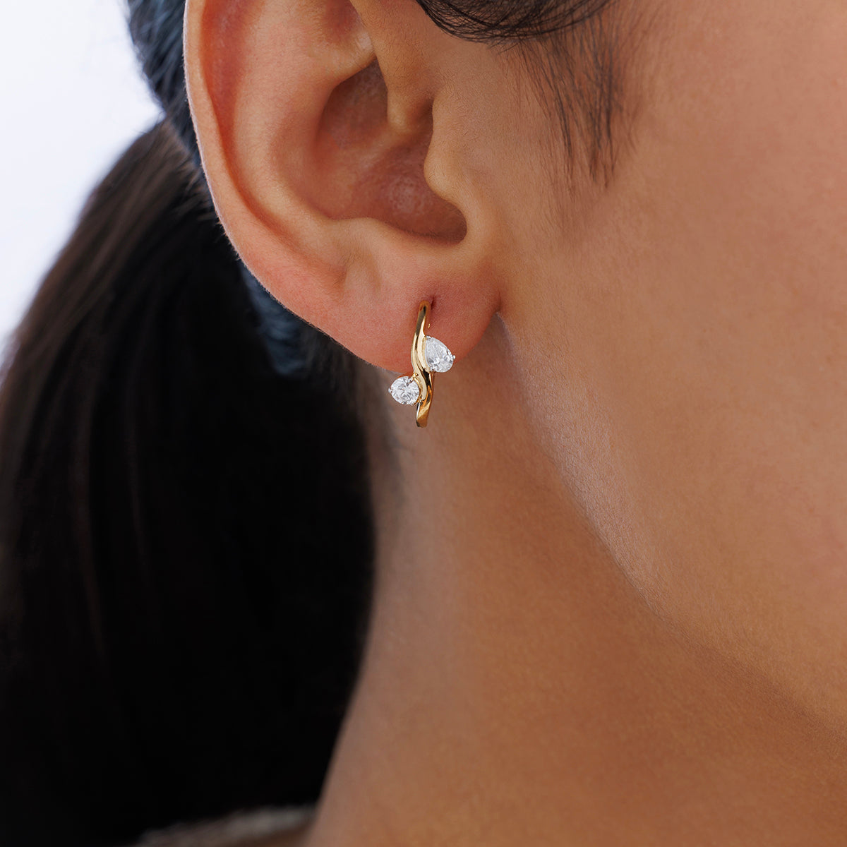 Close-up of a woman's ear wearing Keemti Jewels ORIA Glow Hoop Earrings with two clear gemstones, ideal for daily wear.